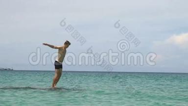 运动的年轻人从石头上<strong>跳入</strong>海洋蓝色的水中。 肌肉探险运动生活方式爱好度假